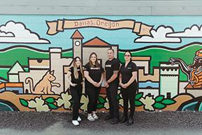 The Workers of Willamette Valley Fiber Outside their building, in front of a Dallas Oregon Mural