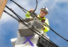 A Xfinity Internet worker, works on a power line
