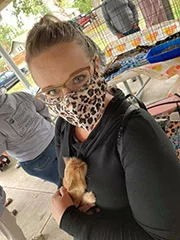 A worker holds an Orange Kitten at Hazels Cat and Kitten Rescue