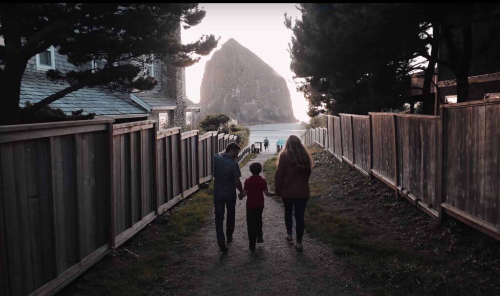 A family walks towards Haystack Rock at Canon Beach