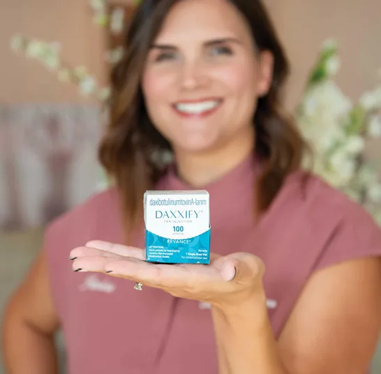 A woman hold a box of Daxxify